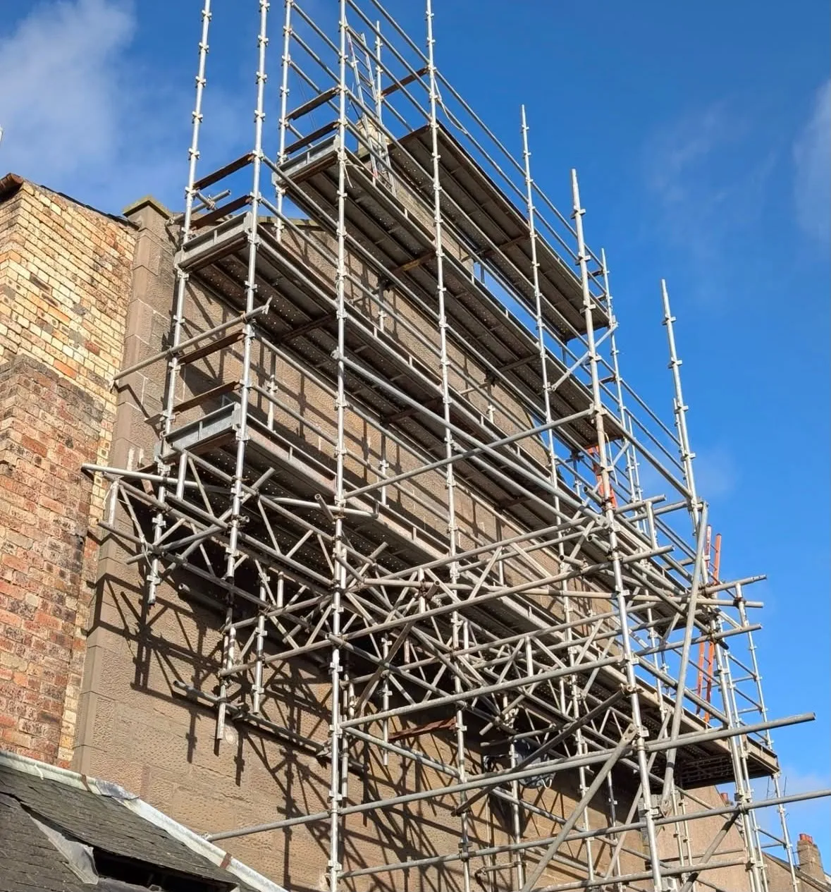 Multi-level scaffolding around a tall stone building